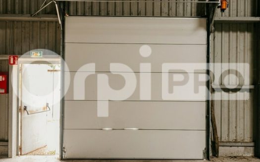 Local professionnel de 433 m² : vastes volumes de stockage, accès plain-pied par porte sectionnelle et bureau/showroom fonctionnel.